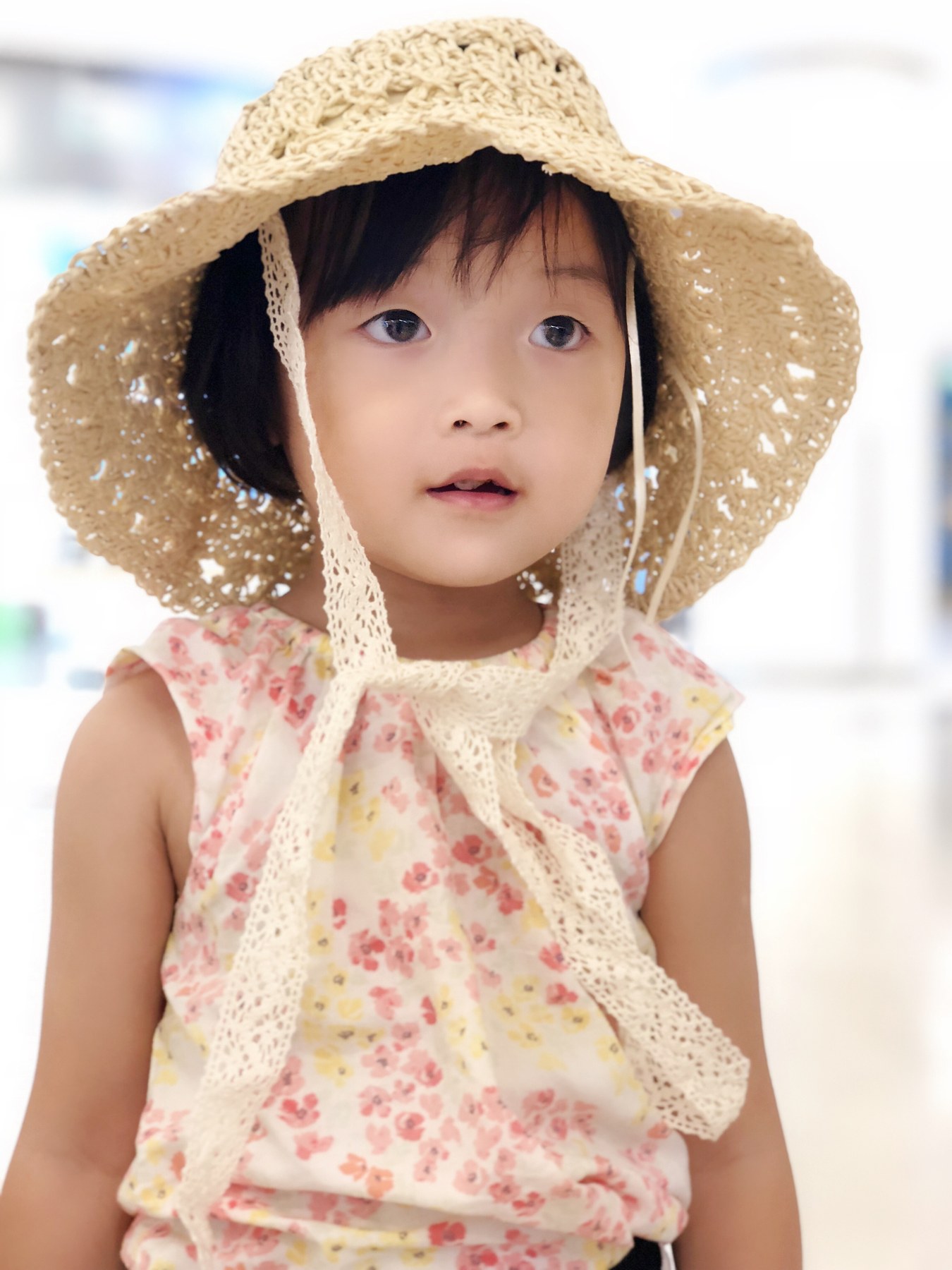 一名戴宽檐草帽并穿花朵上衣的幼年女孩正面半身肖像