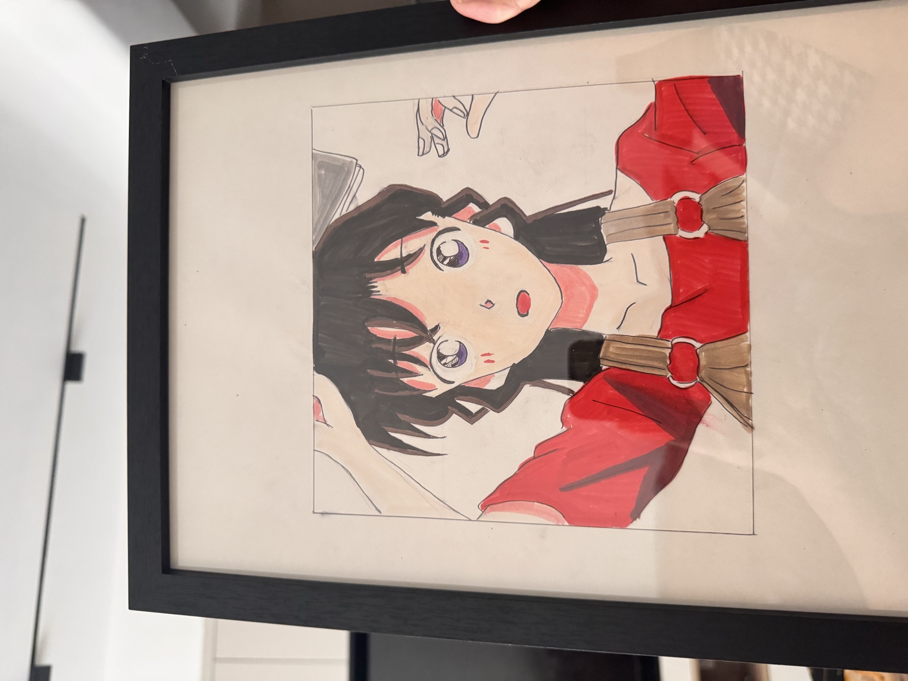 一幅装框的彩色动漫人物手绘作品被手持展示