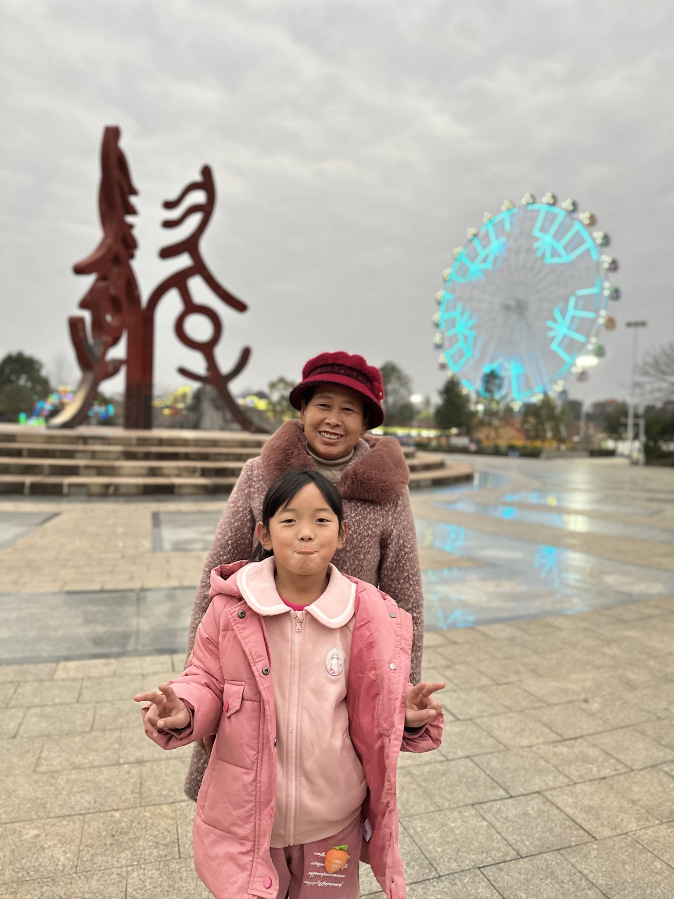 女孩与一名成年女性在公共景点合影