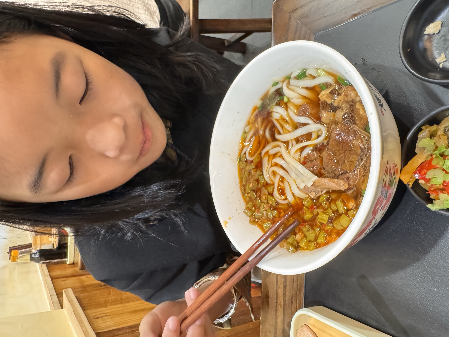 女孩在餐桌前吃面