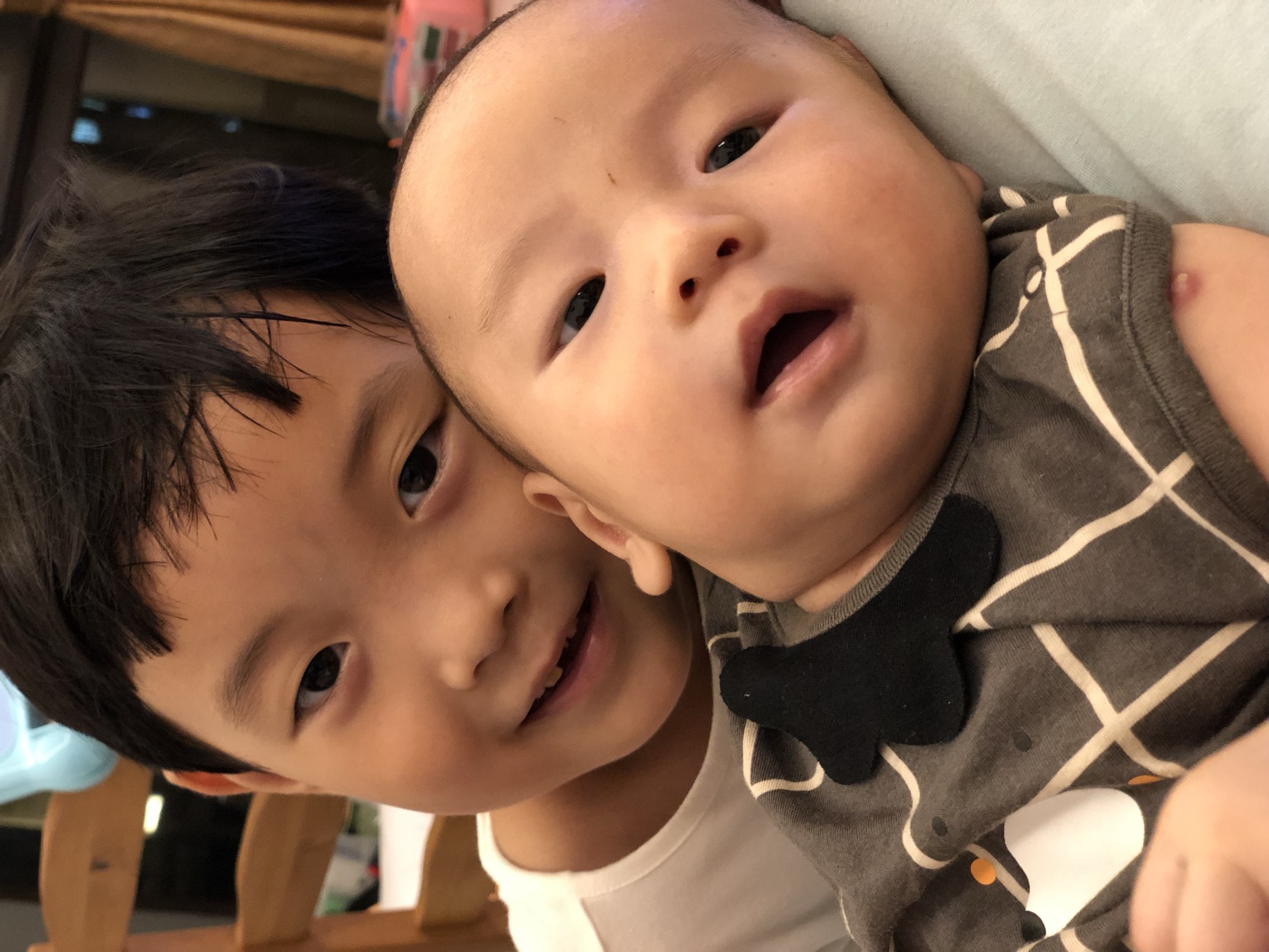 女孩在室内抱着一名婴幼儿