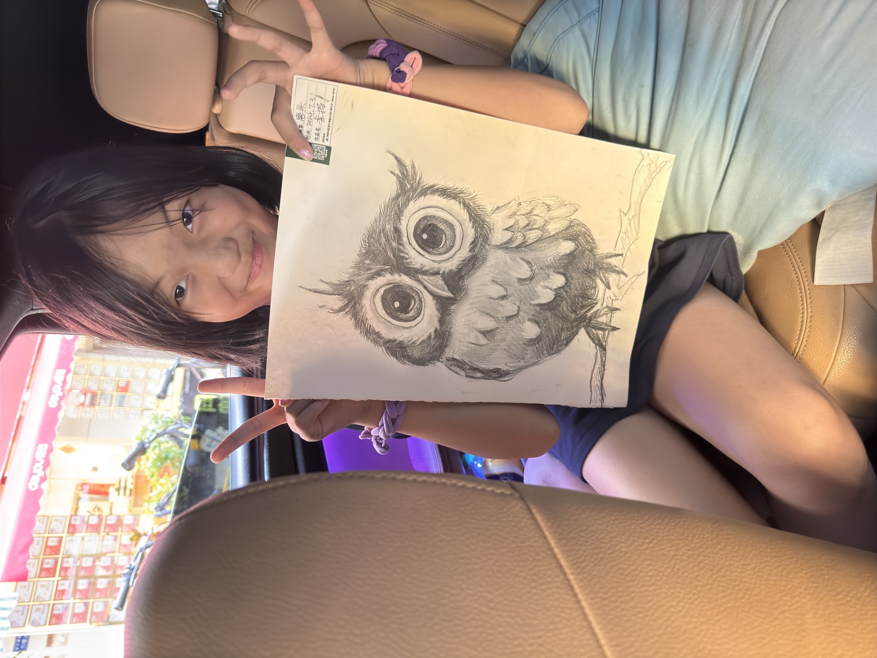 女孩展示一幅猫头鹰主题画作