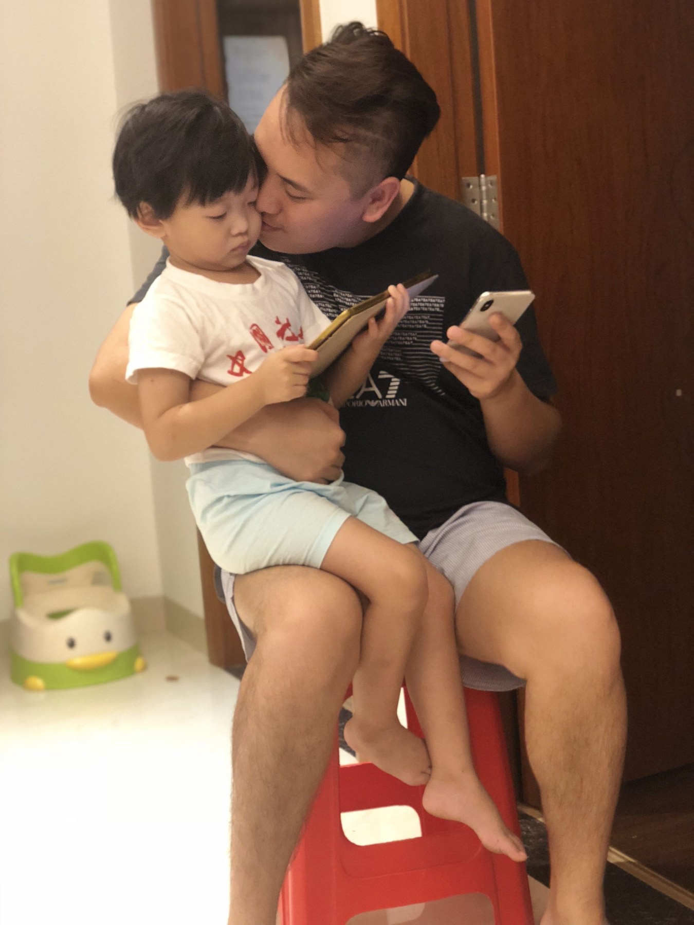 成年男性抱着幼儿并亲吻面颊