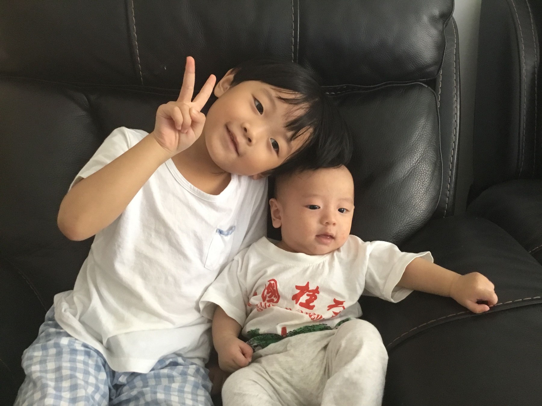 女孩在沙发上靠近并照看婴幼儿