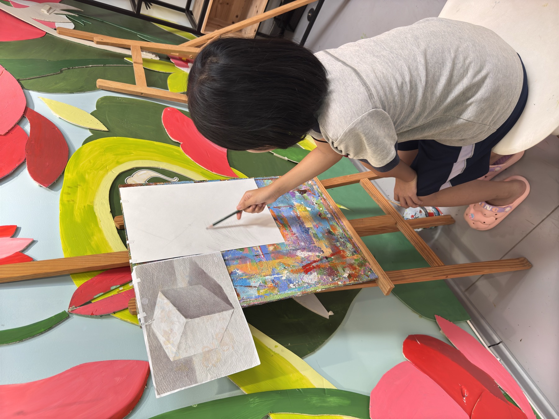 女孩在画架前绘制彩色画作