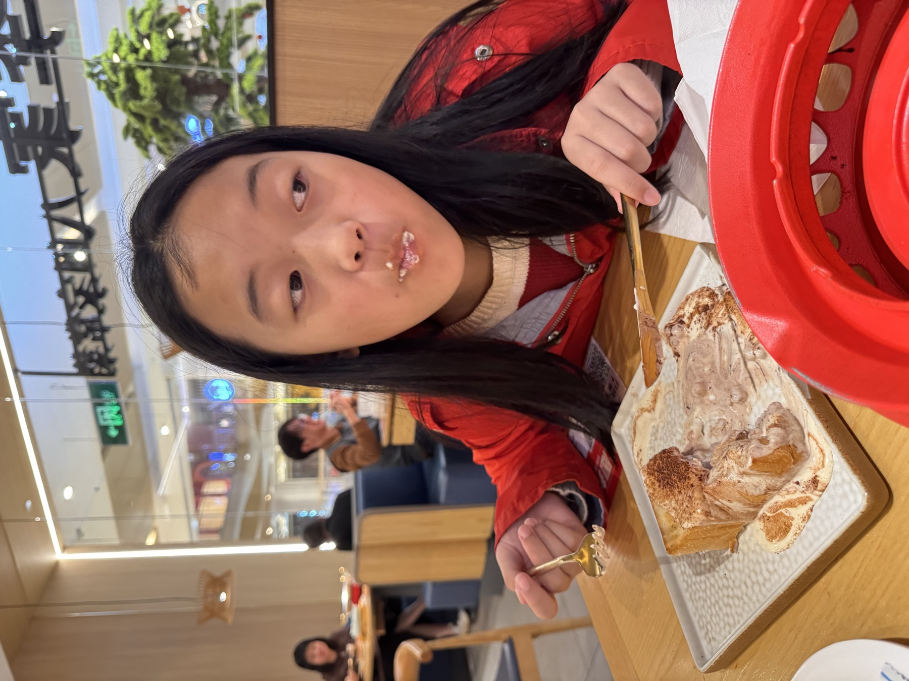 女孩在餐厅吃面食，表情自然
