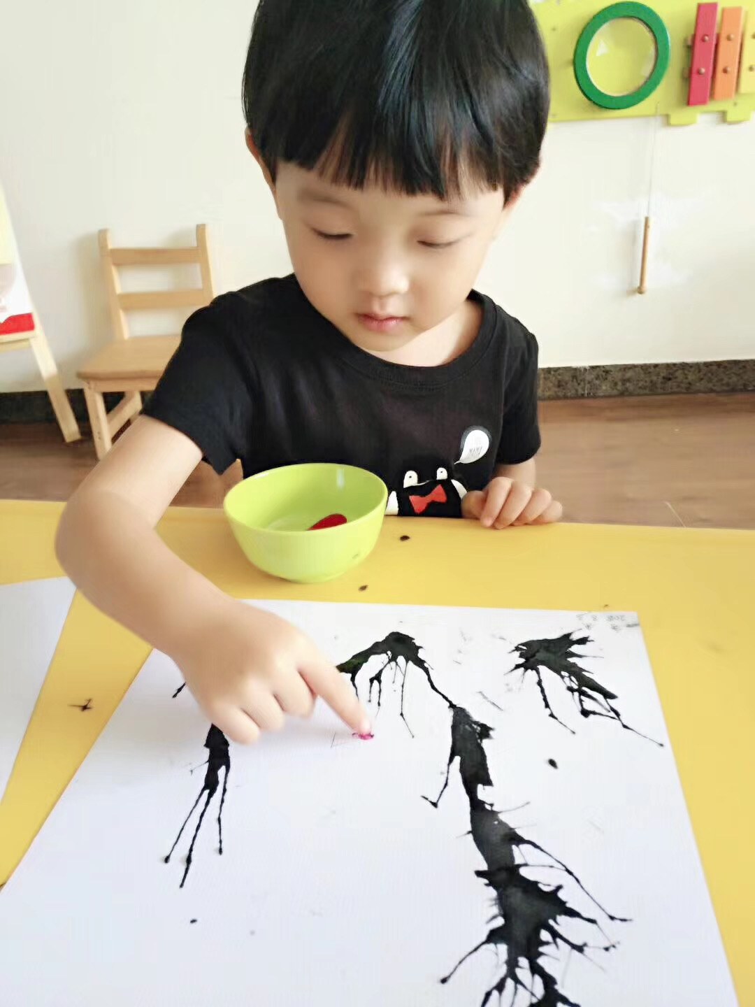 幼儿使用墨色颜料进行绘画或手工