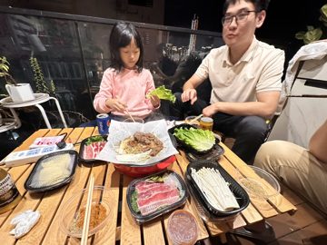 女孩与成年男性在餐桌旁合影