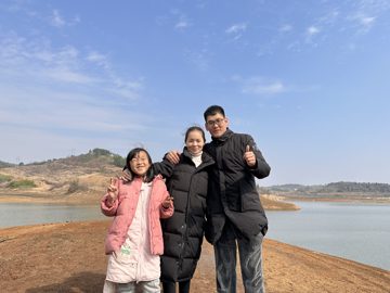 女孩与多名成年人在山水户外环境合影